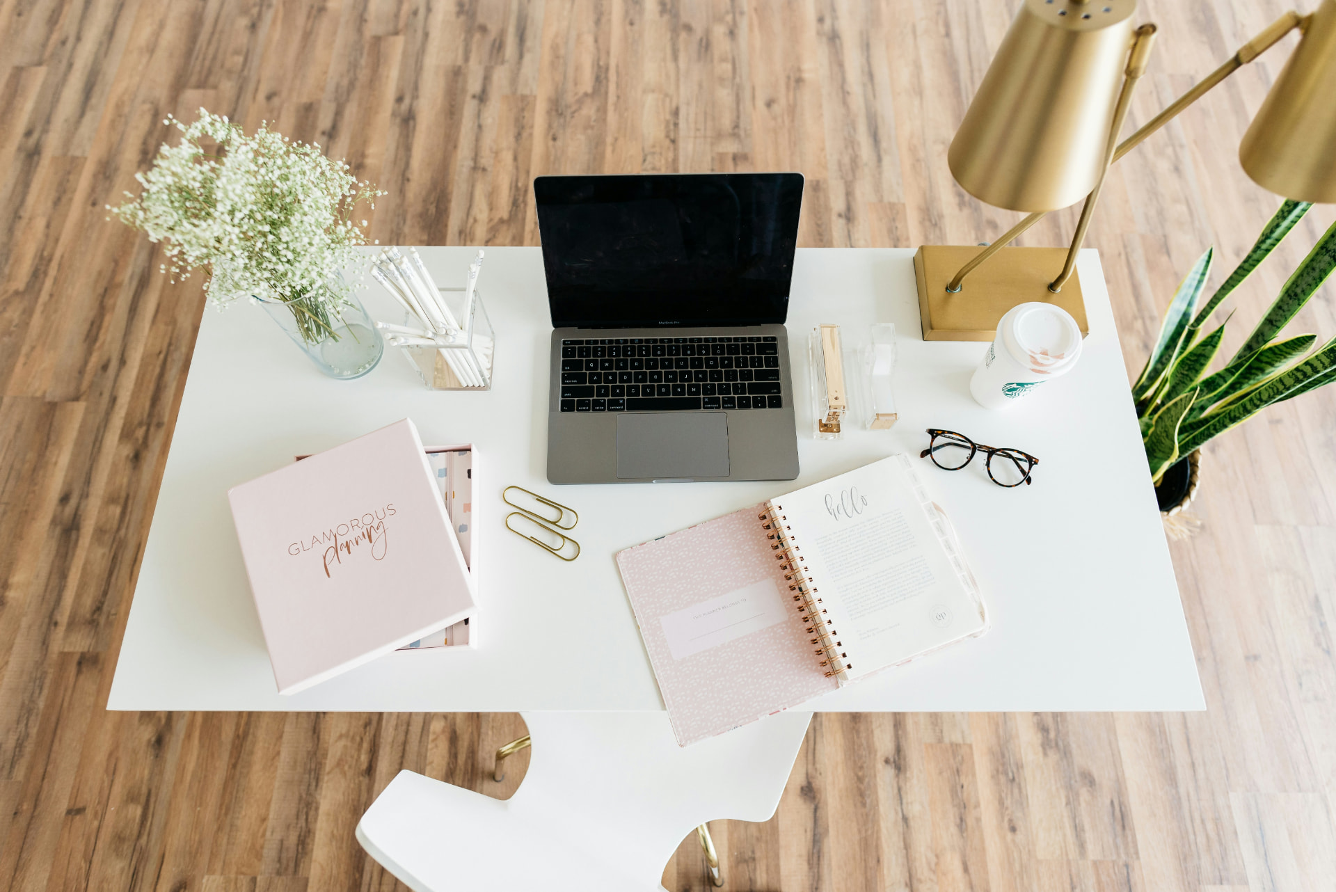 Elegant styled desk with laptop, planner and gold accents